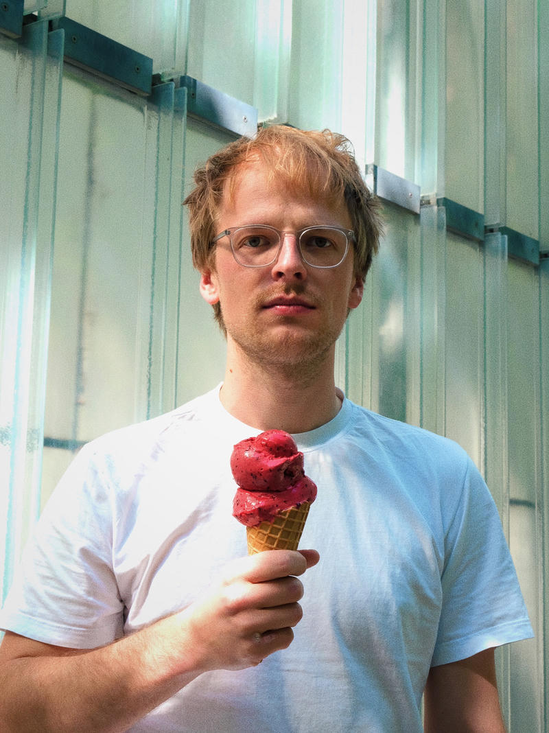 Christopher Heyder mit zwei roten Eiskugeln in der Waffel